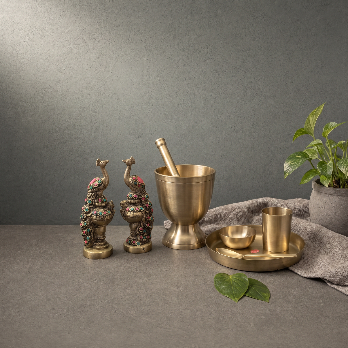 Kansa Khal Musal with Pedestal Foot, Kansa Baby Thali Set, Brass Peacock with Stone Inlay on a stone ledge - Peetal Parampara