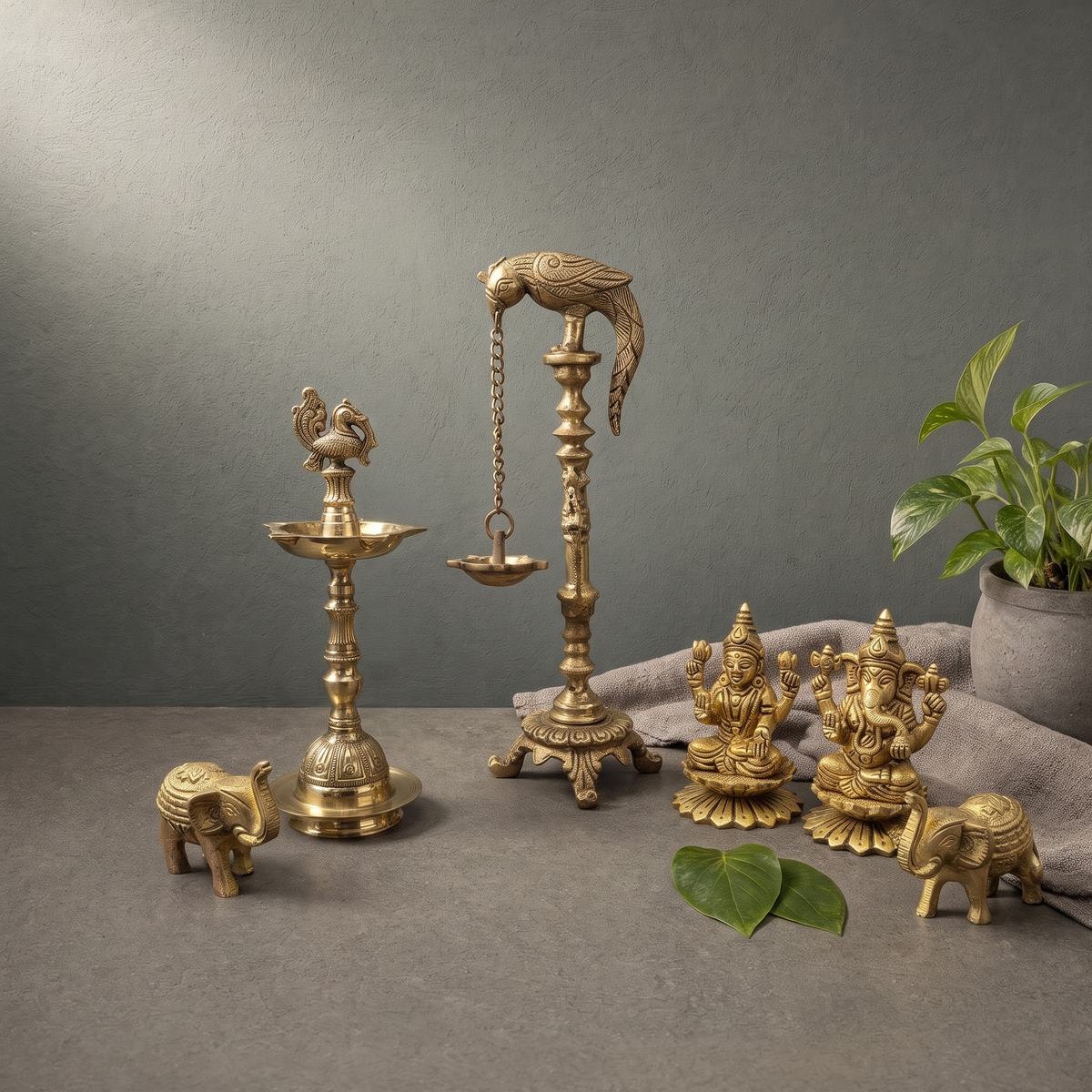 Brass Peacock Standing Diya, Brass Laxmi Ganesh Murti on a stone ledge - Peetal Parampara
