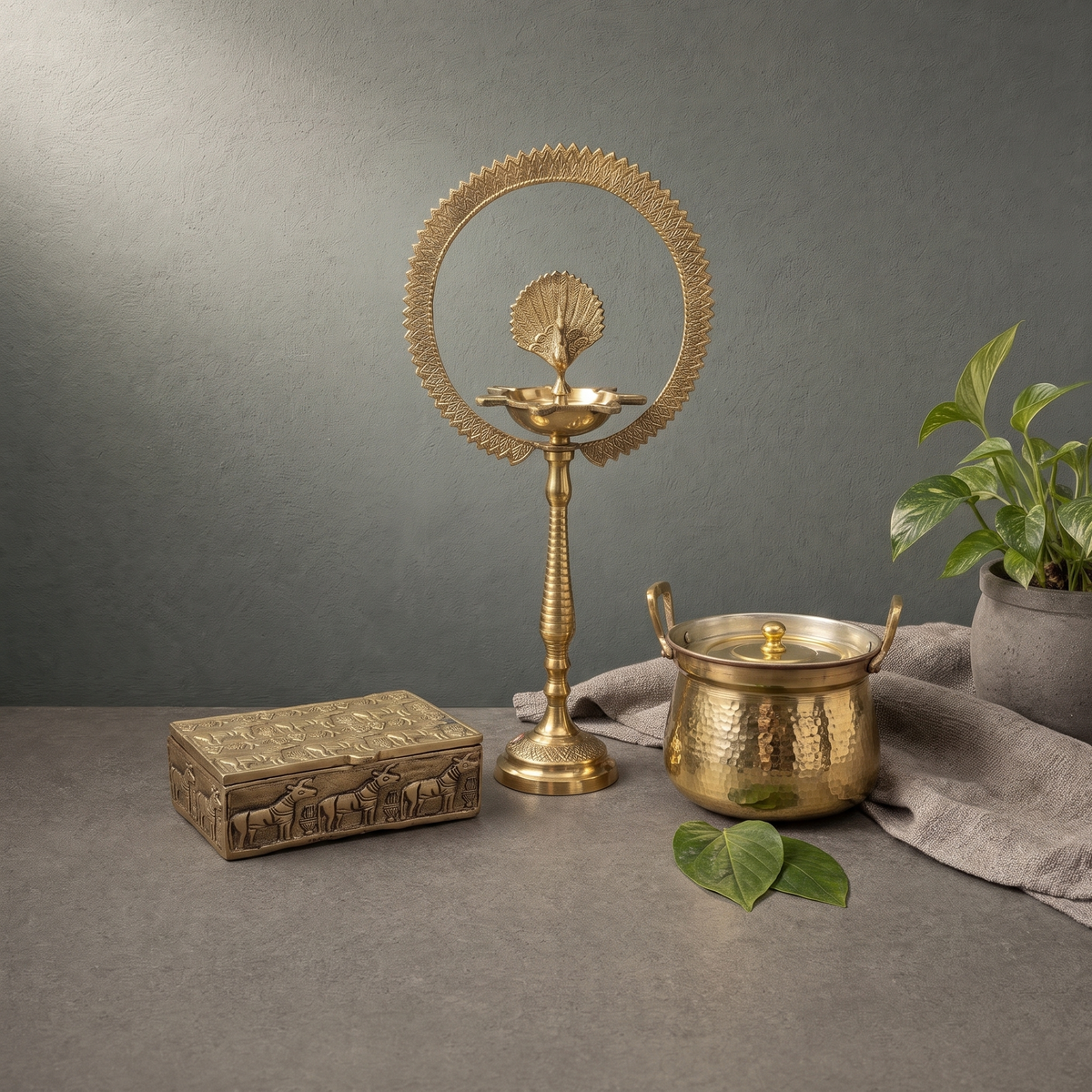 Brass Peacock Diya with Halo Ring, Antique Brass Jewellery Box on a stone ledge - Peetal Parampara