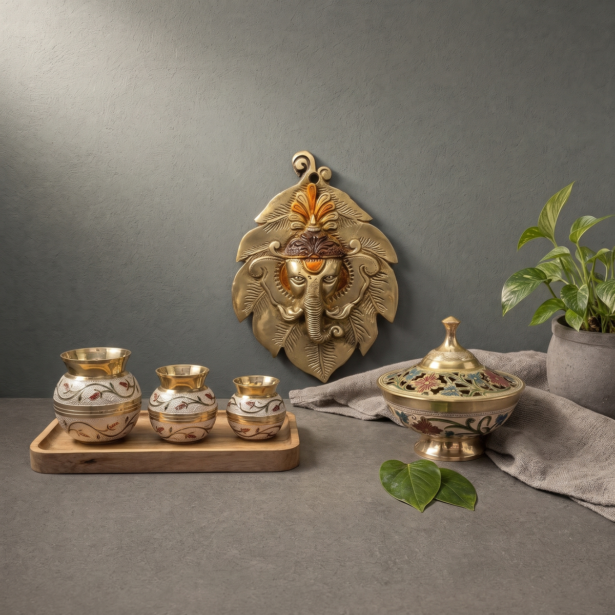 Hand Painted Brass Ganesha on Leaf, Hand Painted Brass Bowl with Pierced Lid on a stone ledge - Peetal Parampara