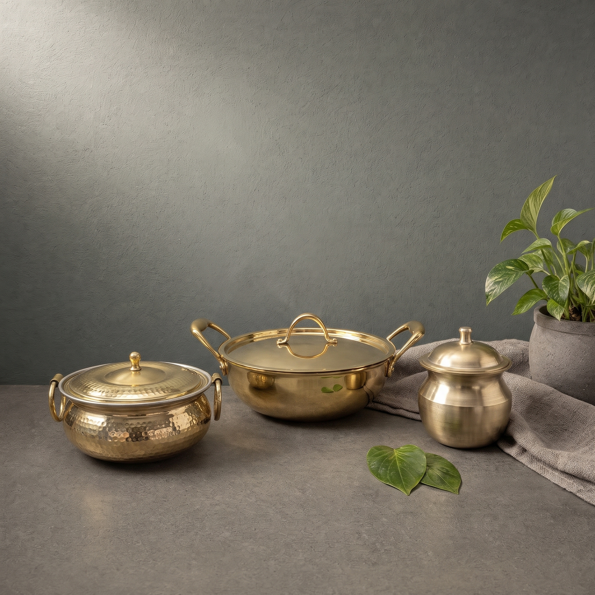 Brass Kadhai with Arched Lid Handle, Kansa Ghee Pot with Domed Lid on a stone ledge - Peetal Parampara