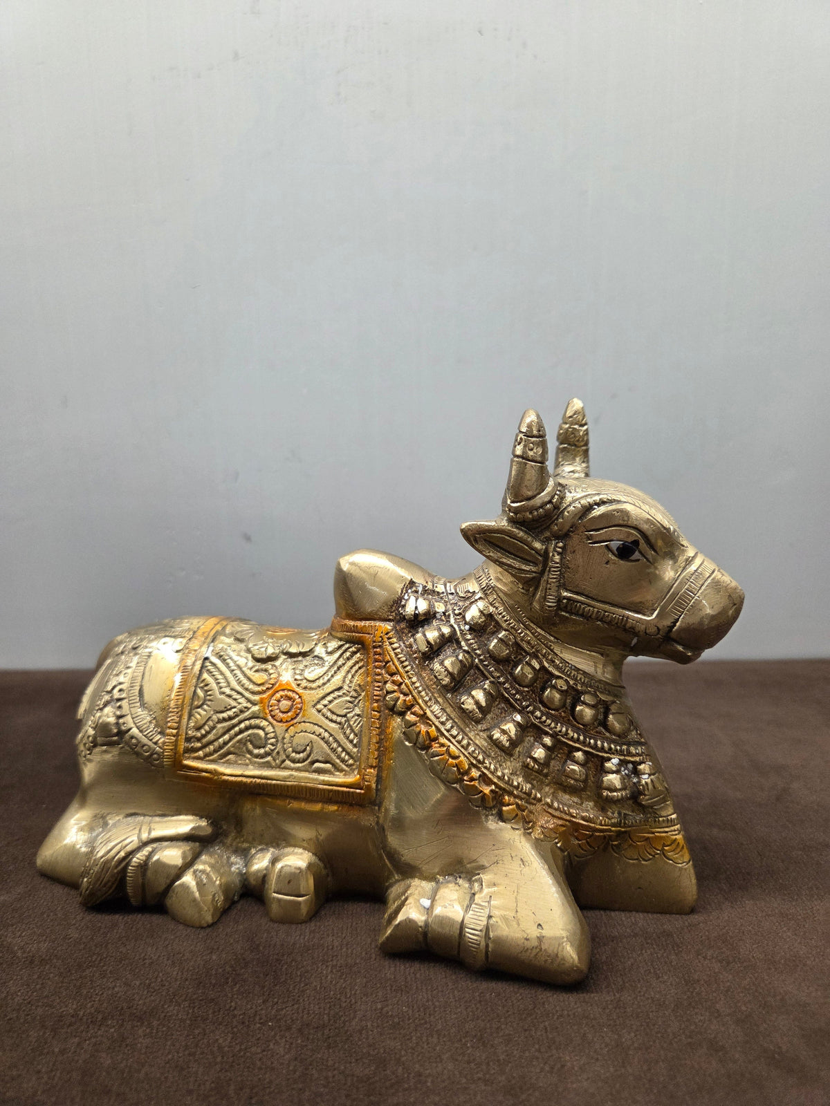 Hand painted brass Nandi couchant, orange colour in the saddle border and rosette, bell collar - Peetal Parampara
