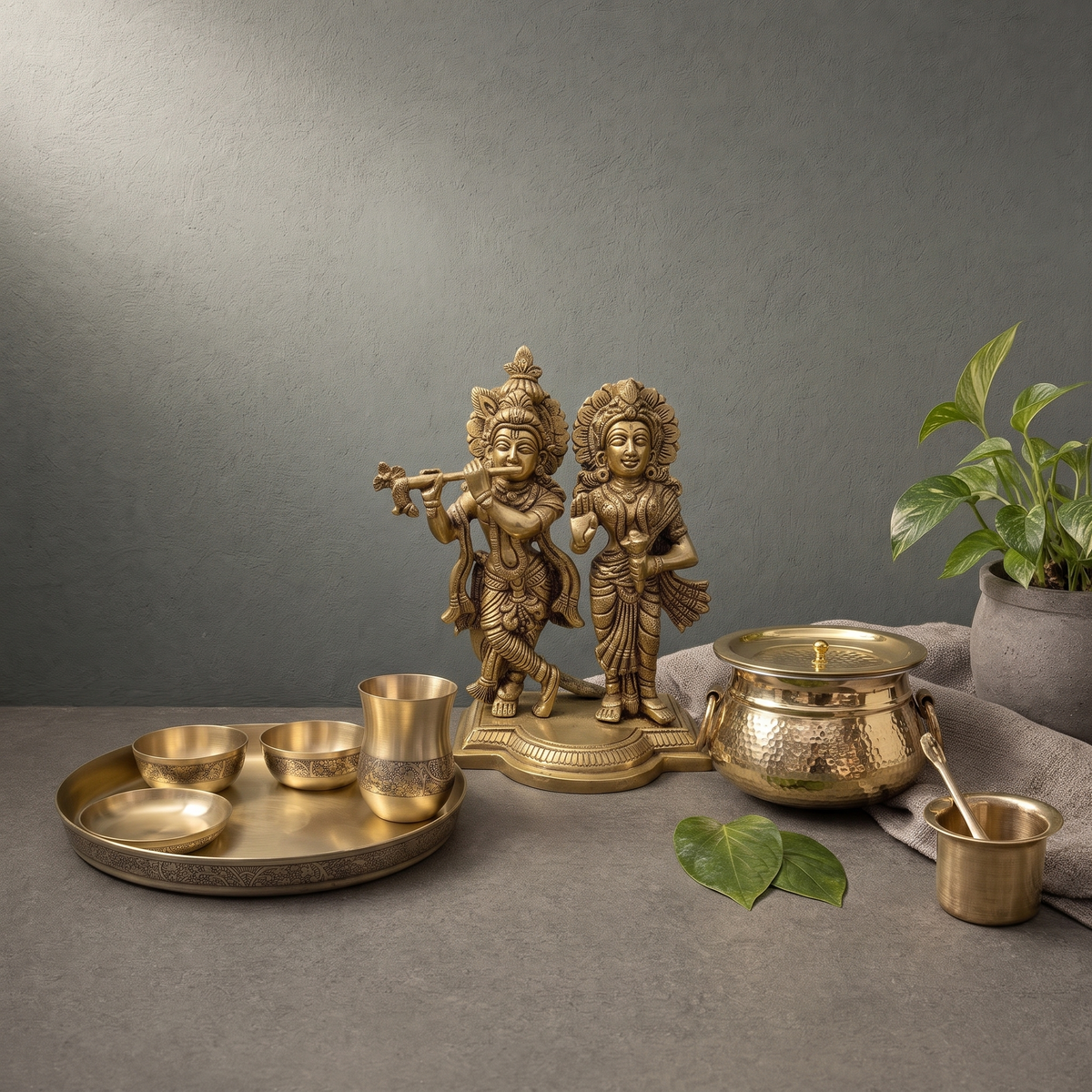 Hand Engraved Kansa Thali Set, Hand Hammered Brass Mughlai Handi on a stone ledge - Peetal Parampara