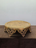 Round brass chowki with an engraved rosette top plate, a pierced apron and cast leaf brackets for feet - Peetal Parampara