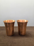 Two flared copper tumblers hammered in oval facets, narrow at the base and rolled over at the wide lip - Peetal Parampara
