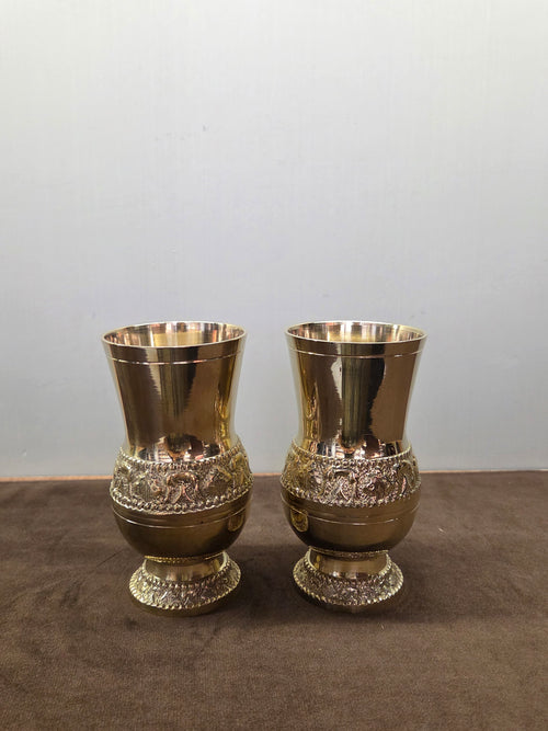 Two footed brass glasses with a raised band of figures between beaded ropes at the waist and on the foot - Peetal Parampara