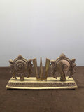 Cast brass sudarshan disc, three-pronged namah and spiral conch standing in a row on an engraved plinth - Peetal Parampara