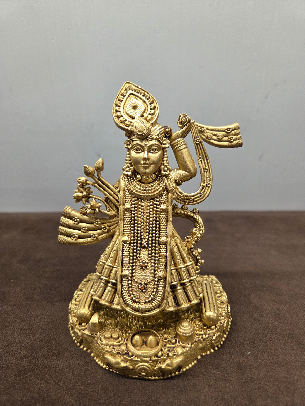 Brass Shrinathji murti with the left arm raised, long bead strands and a conch on the domed base - Peetal Parampara