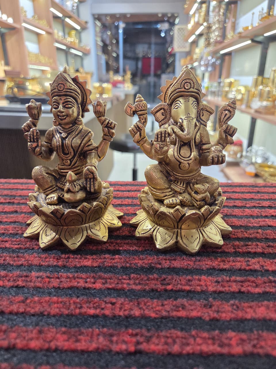 Pair of cast brass Laxmi and Ganesh figures on flared lotus bases, four arms each, mouse at a corner - Peetal Parampara