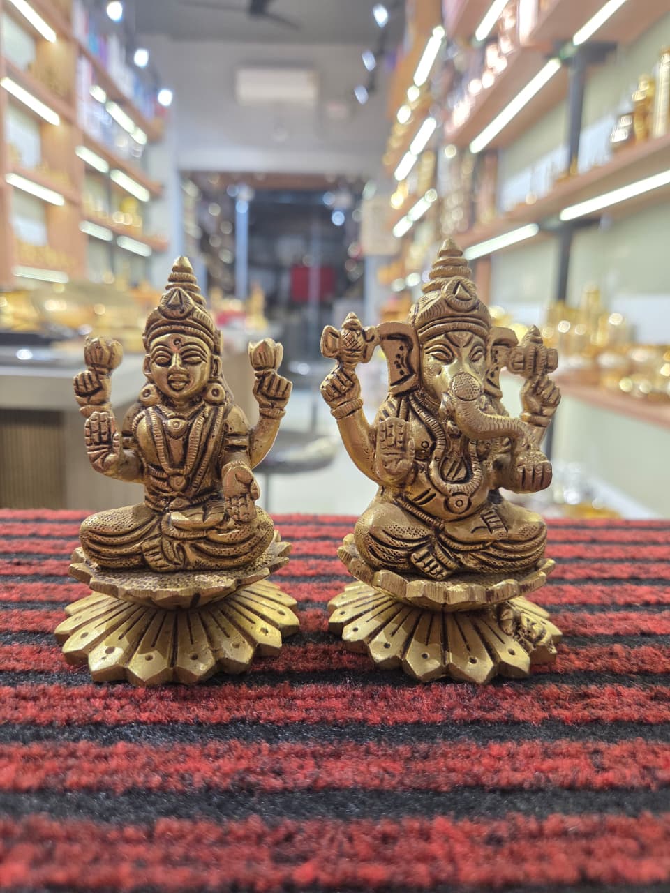 Pair of cast brass Laxmi and Ganesh figures on flared lotus bases, four arms each, mouse at a corner - Peetal Parampara
