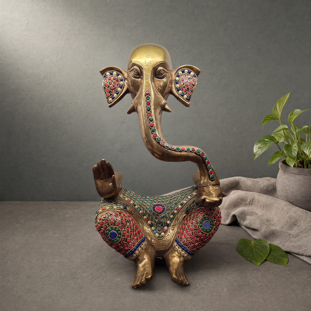 Antique Brass Ganesh Murti with Stone Inlay on a stone ledge against a grey plaster wall - Peetal Parampara