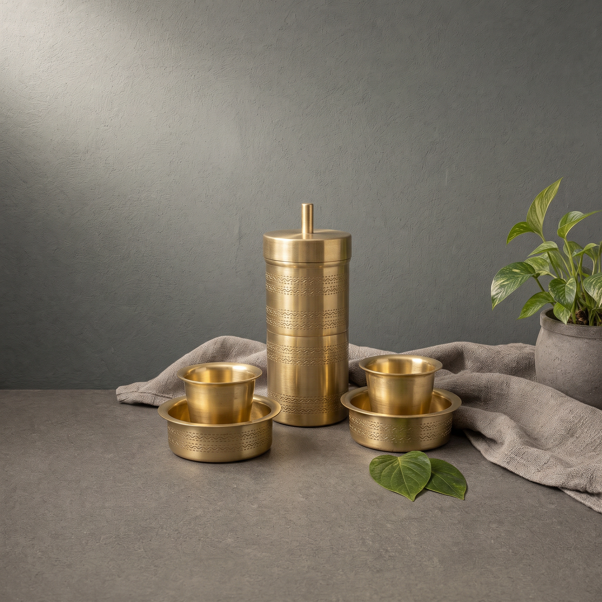 Brass Filter Coffee Set on a stone ledge against a grey plaster wall - Peetal Parampara