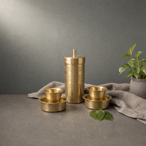 Brass Filter Coffee Set on a stone ledge against a grey plaster wall - Peetal Parampara