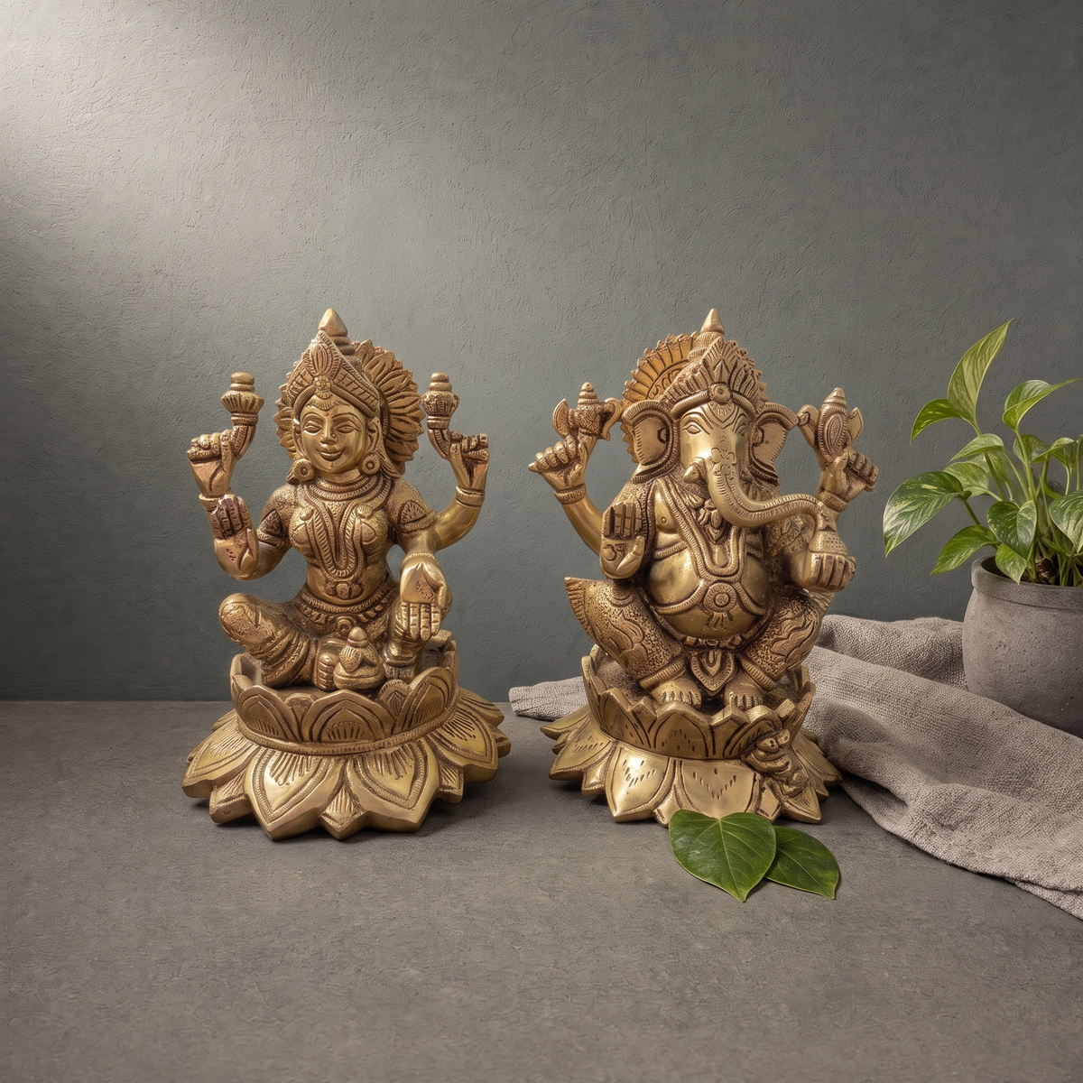 Brass Laxmi Ganesh Murti on Lotus on a stone ledge against a grey plaster wall - Peetal Parampara