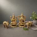 Brass Laxmi Ganesh Murti on a stone ledge against a grey plaster wall - Peetal Parampara