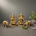 Brass Laxmi Ganesh Murti on a stone ledge against a grey plaster wall - Peetal Parampara
