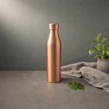 Copper Bottle with Collar Cap on a stone ledge against a grey plaster wall - Peetal Parampara